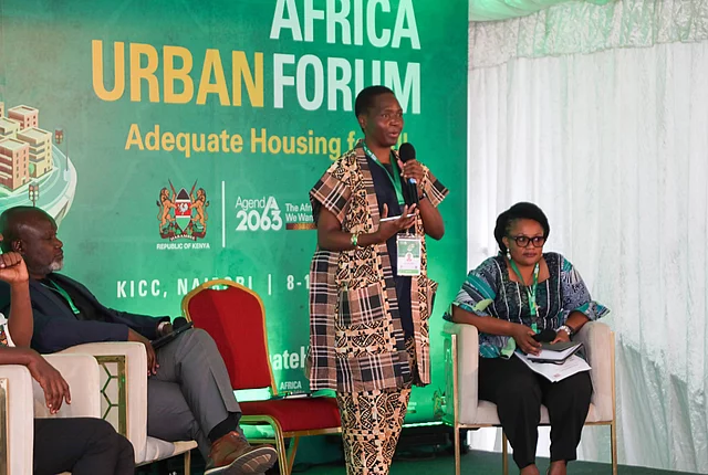Panel discussion at Africa Urban Forum 2 in Nairobi, with one speaker standing and two panelists seated on stage
